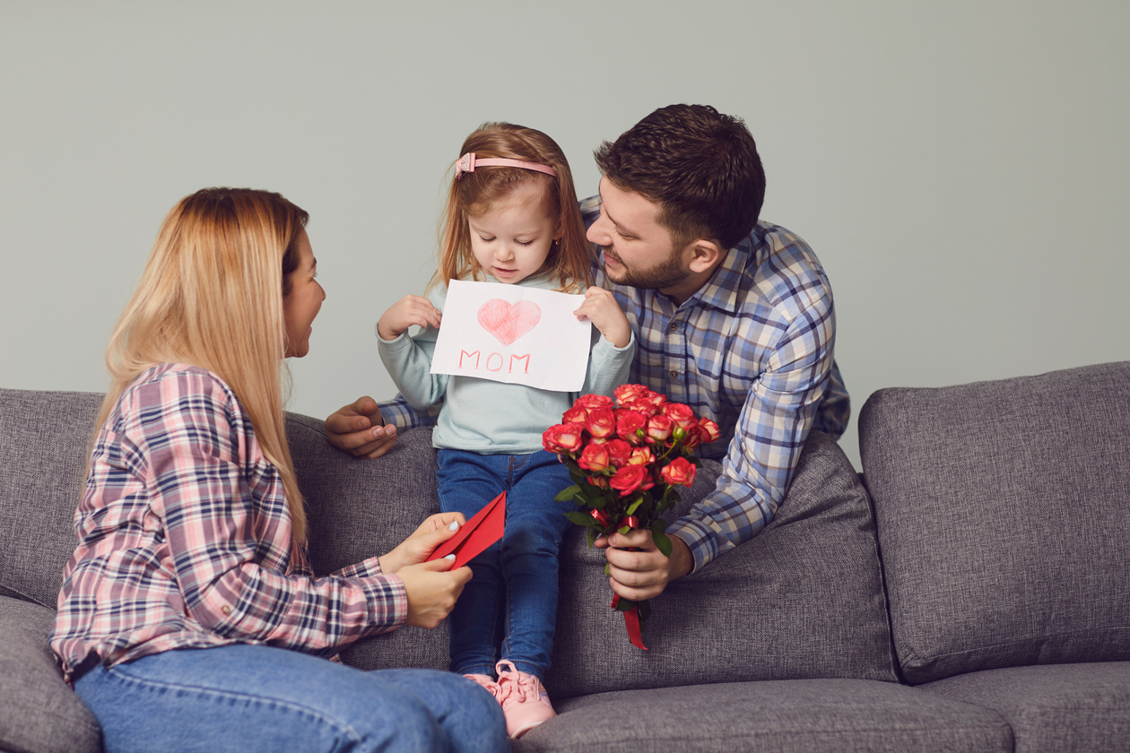 Happy Mother's Day. Daughter Gives Mom a Card with Heart Flowers Gift